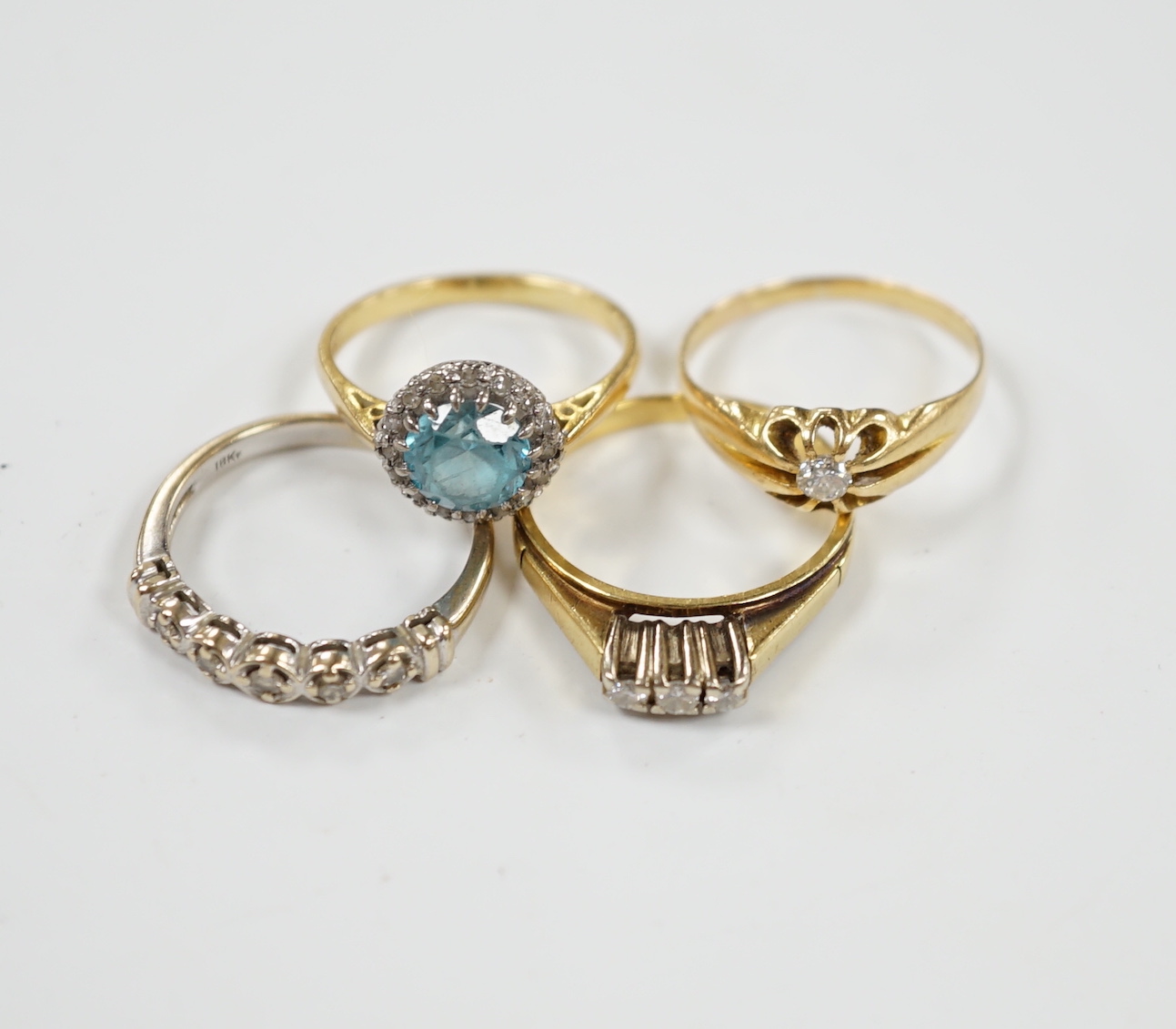 Three assorted 18ct and gem set dress rings, including blue zircon and diamond chip and claw set solitaire and one other yellow metal and gem set ring, gross weight 12.6 grams.